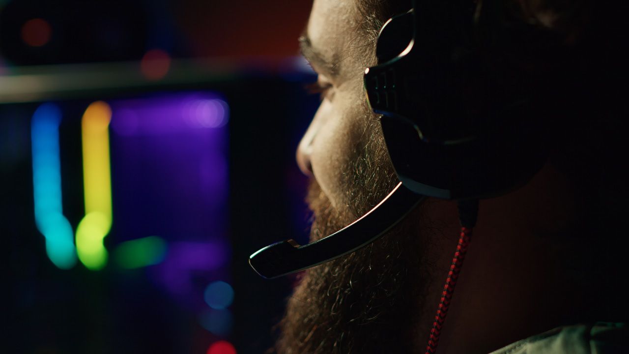 gamer-battling-enemies-multiplayer-shooter-discussing-with-other-players-through-headphones-mic.jpg